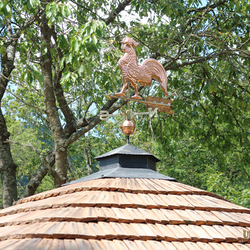 Coq en cuivre sur un toit en fer forg� � kiosque d'�t� devant une maison individuelle