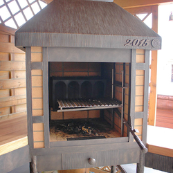 Chemin�e forg�e pour barbecue dans le jardin d'une maison familiale