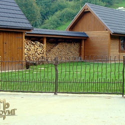 Portail à double battants compos� des barreaux ronds, ond�s et forg� � martel� à chaud.