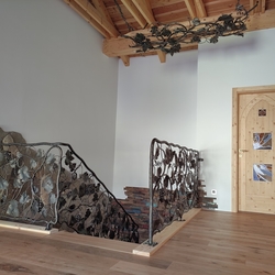 Rampe d’escalier artisanale en fer forgé, ornée d’un motif de vigne, installée dans une maison familiale en Moravie Rampe d’escalier artisanale en fer forgé, ornée d’un motif de vigne, installée dans une maison familiale en Moravie