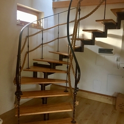 Escalier en fer forg� en colima�on avec balustrade, compl�t� par une corde, dans l'int�rieur d'une maison familiale